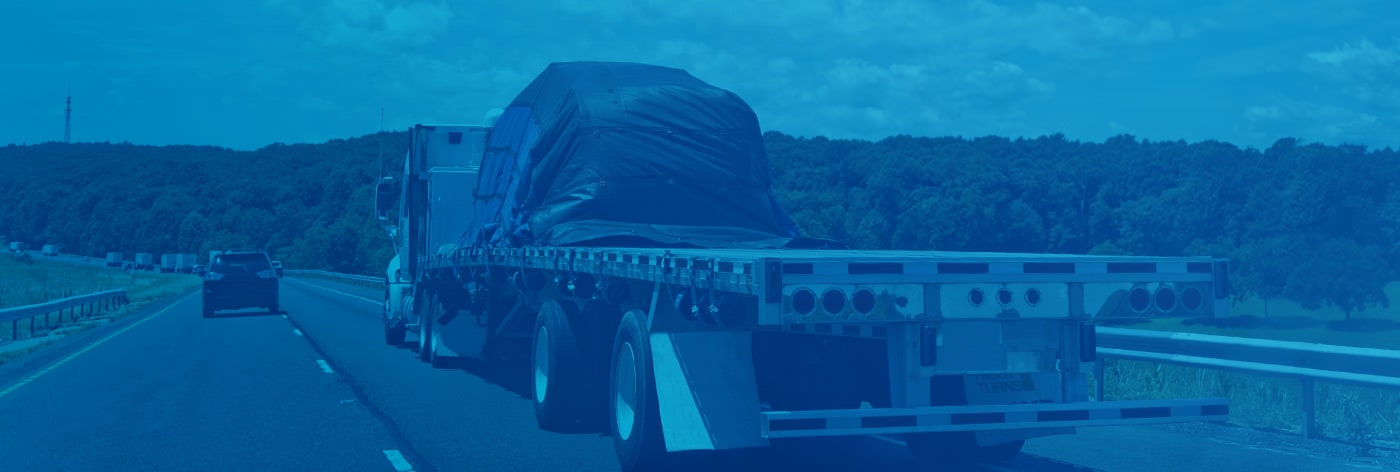 A loaded flatbed trailer transporting freight by road.